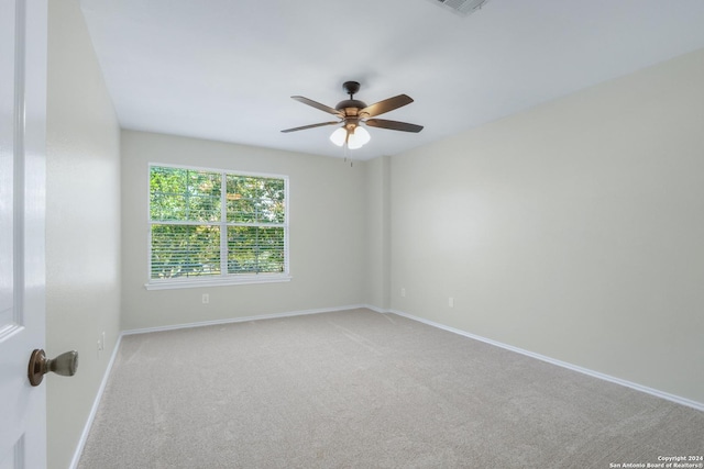 empty room with ceiling fan, baseboards, and light colored carpet