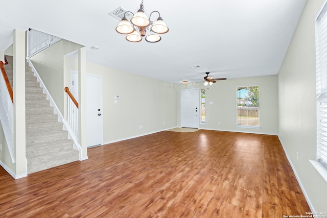 unfurnished living room featuring ceiling fan with notable chandelier and wood-type flooring