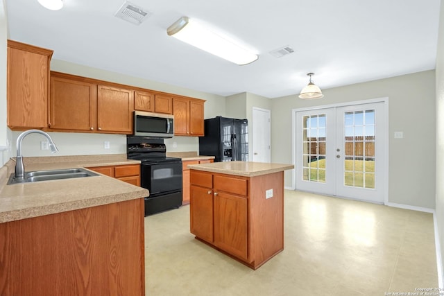 kitchen with a sink, a kitchen island, hanging light fixtures, light countertops, and black appliances