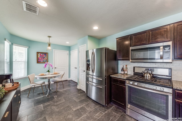 kitchen with appliances with stainless steel finishes, pendant lighting, decorative backsplash, and dark brown cabinetry