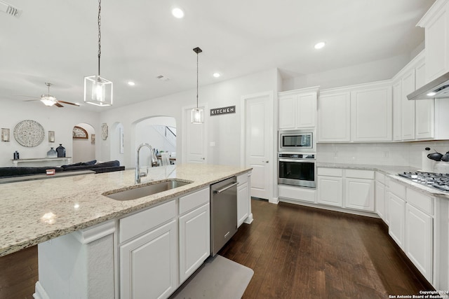 kitchen with appliances with stainless steel finishes, sink, white cabinets, dark hardwood / wood-style flooring, and ceiling fan