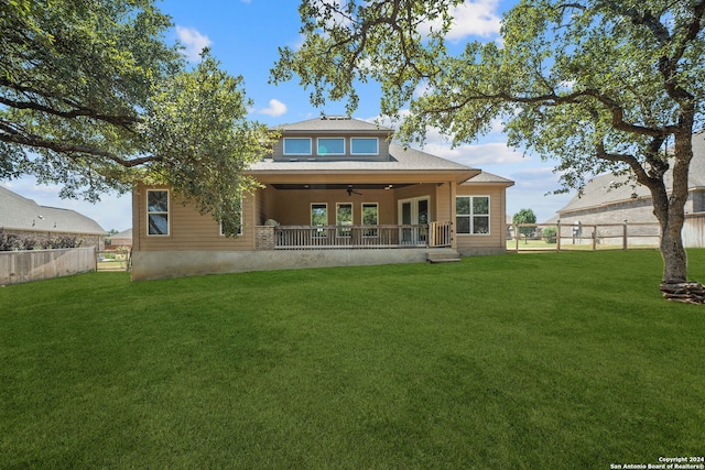 back of property featuring ceiling fan and a lawn