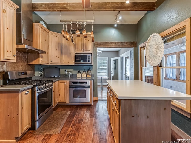 kitchen with wall chimney range hood, dark hardwood / wood-style flooring, tasteful backsplash, appliances with stainless steel finishes, and rail lighting