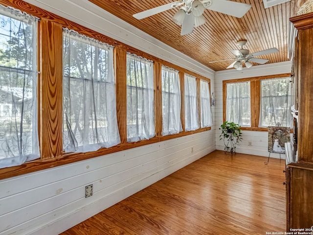 unfurnished sunroom with wood ceiling and ceiling fan