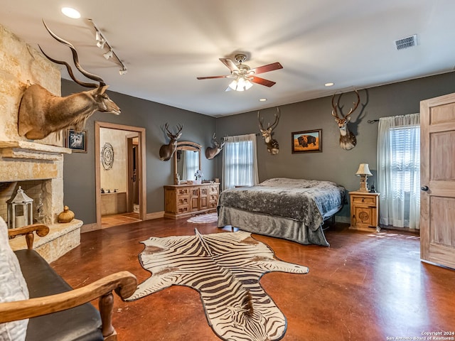 bedroom featuring ceiling fan, rail lighting, connected bathroom, and multiple windows