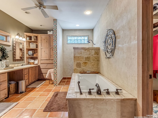 bathroom featuring tiled tub, tile patterned flooring, vanity, and ceiling fan