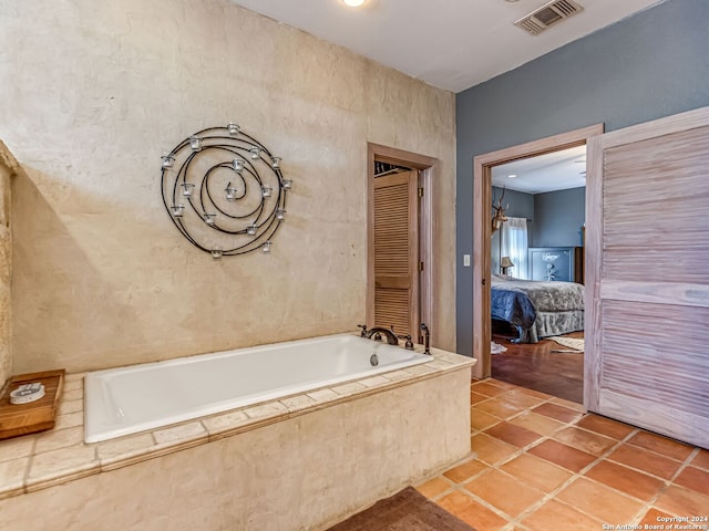 bathroom with tile patterned flooring and tiled tub