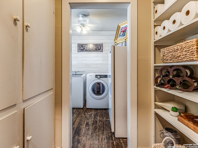 washroom featuring ceiling fan, washing machine and clothes dryer, wood walls, and dark wood-type flooring