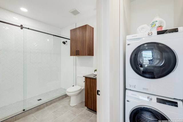 laundry area with stacked washer and clothes dryer, visible vents, and laundry area