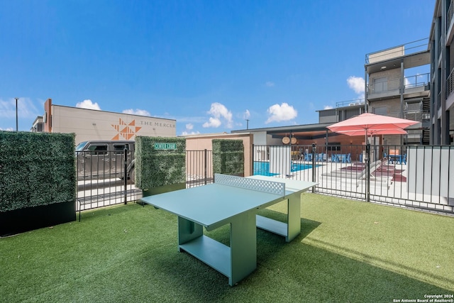 view of home's community featuring a yard, fence, and a swimming pool