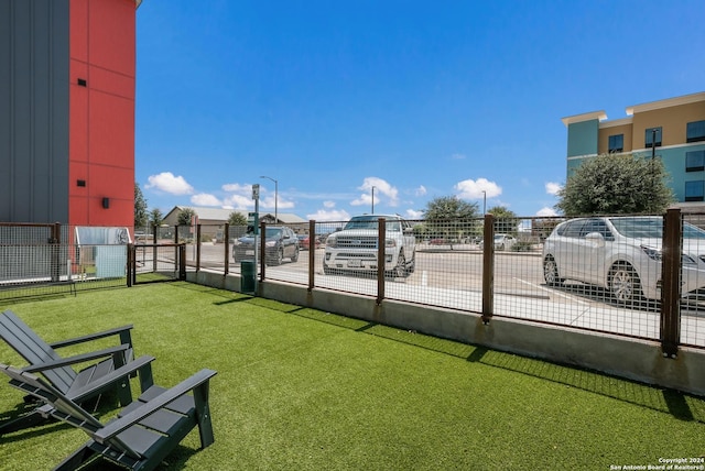 view of home's community with a yard and fence