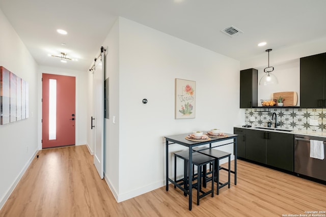 kitchen with open shelves, light countertops, a barn door, a sink, and dark cabinetry