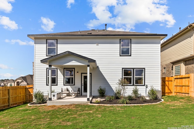 back of house with a patio area and a lawn