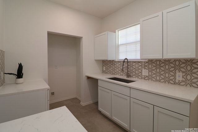 kitchen featuring backsplash, sink, and white cabinets