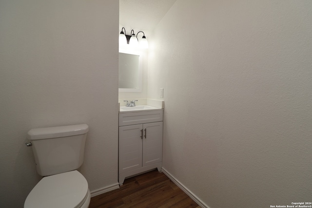 bathroom with wood-type flooring, toilet, and vanity