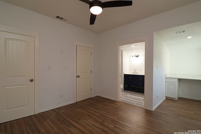 unfurnished bedroom with ceiling fan, connected bathroom, sink, and dark wood-type flooring