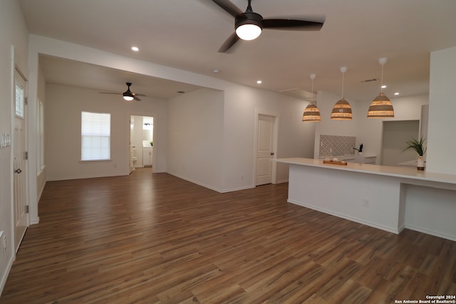 unfurnished living room featuring ceiling fan and dark hardwood / wood-style flooring