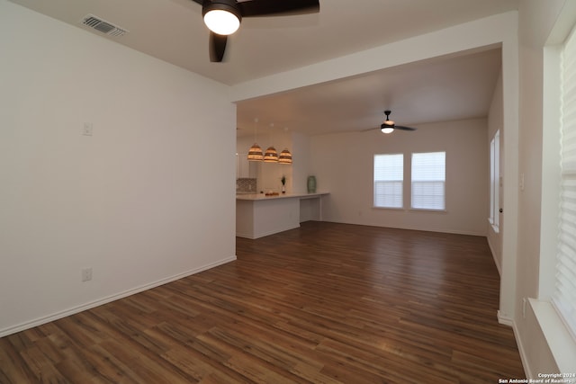 unfurnished living room featuring ceiling fan and dark hardwood / wood-style floors