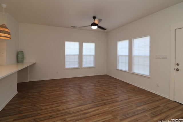 unfurnished living room featuring a wealth of natural light, dark hardwood / wood-style floors, and ceiling fan