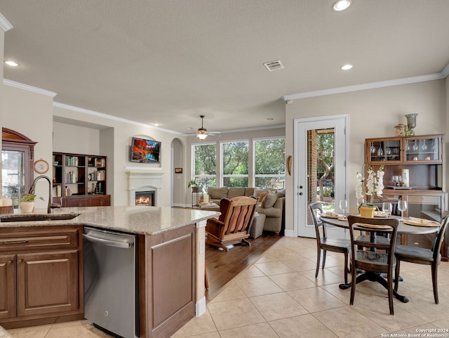 kitchen featuring light hardwood / wood-style floors, stainless steel dishwasher, sink, crown molding, and ceiling fan