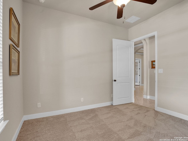 carpeted spare room featuring ceiling fan