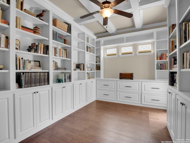 unfurnished office with built in shelves, coffered ceiling, beamed ceiling, wood-type flooring, and ceiling fan