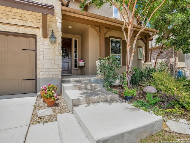 view of exterior entry with a garage and a porch