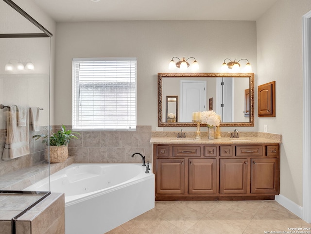 bathroom featuring tile patterned flooring, a relaxing tiled tub, and vanity