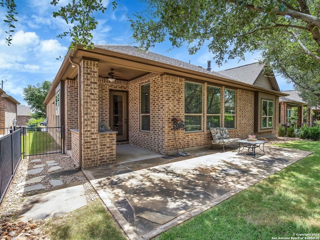 back of house with ceiling fan, a yard, and a patio