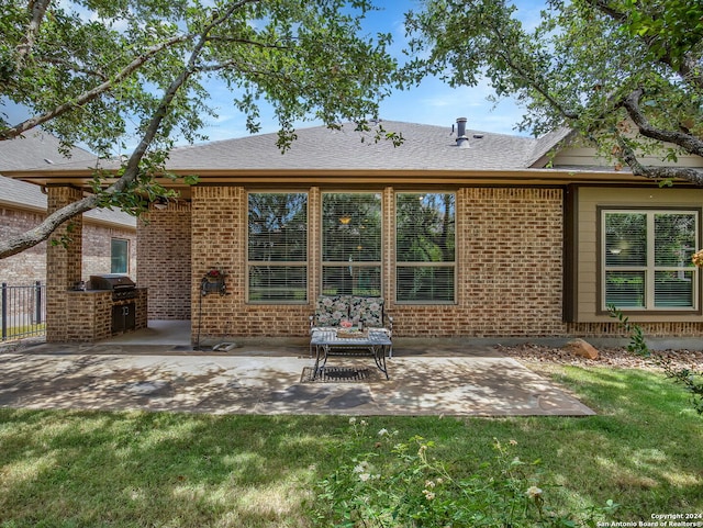 rear view of house with a yard, a patio, brick siding, and fence