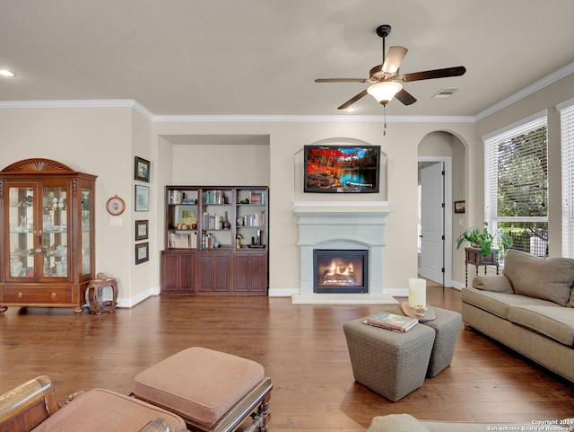 living room featuring ceiling fan, wood-type flooring, and ornamental molding