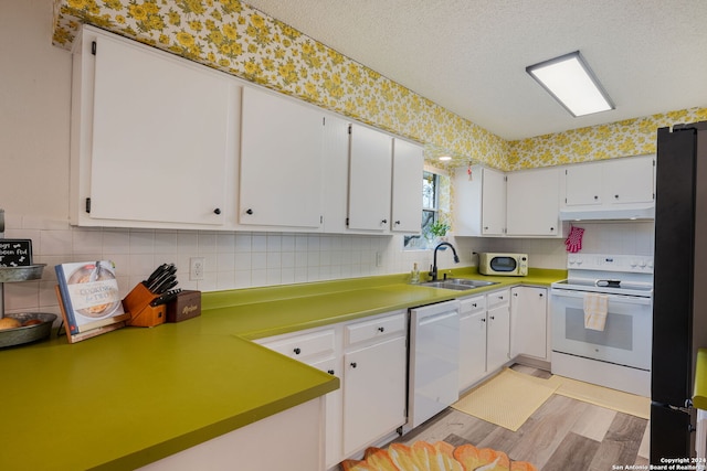 kitchen featuring sink, light hardwood / wood-style flooring, white appliances, a textured ceiling, and white cabinets