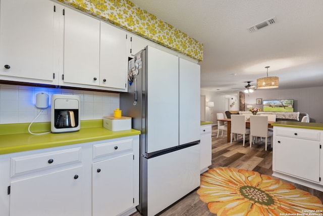 kitchen with backsplash, light hardwood / wood-style floors, white cabinets, ceiling fan, and white fridge