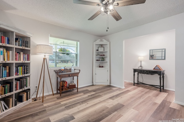 interior space featuring a textured ceiling, ceiling fan, and light wood-type flooring