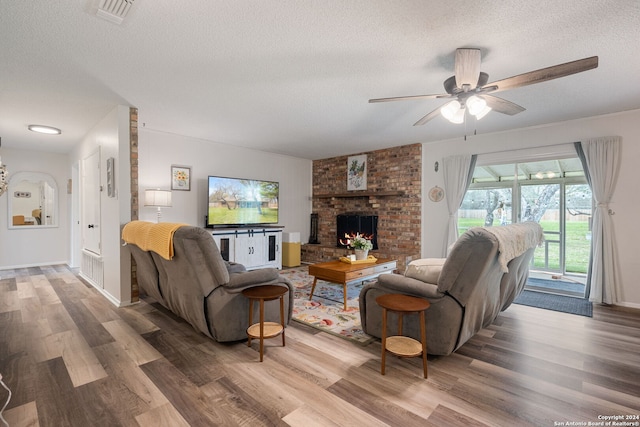 living room featuring a wealth of natural light, a fireplace, and hardwood / wood-style floors