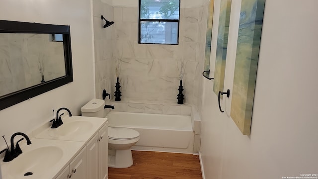 full bathroom with tiled shower / bath, vanity, hardwood / wood-style floors, and toilet