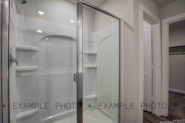 bathroom featuring hardwood / wood-style flooring and a shower with door