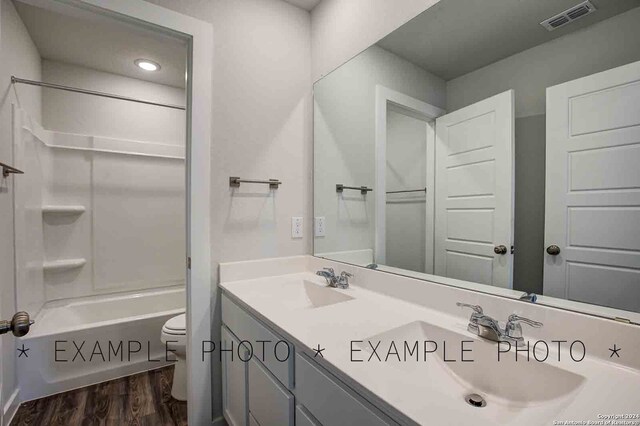 full bathroom with hardwood / wood-style floors, vanity, toilet, and bathing tub / shower combination