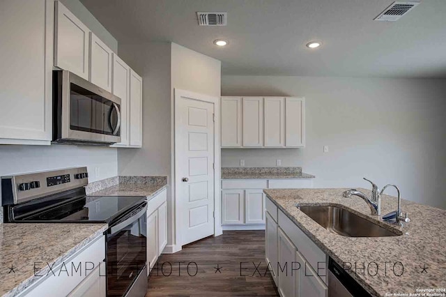 kitchen with light stone countertops, stainless steel appliances, white cabinets, and dark hardwood / wood-style floors