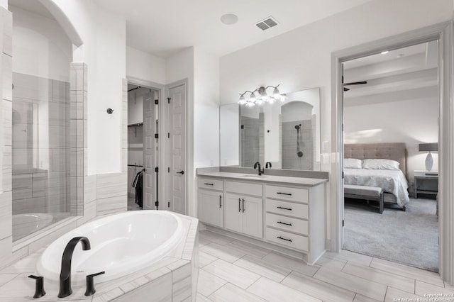 bathroom featuring plus walk in shower, tile patterned floors, and vanity