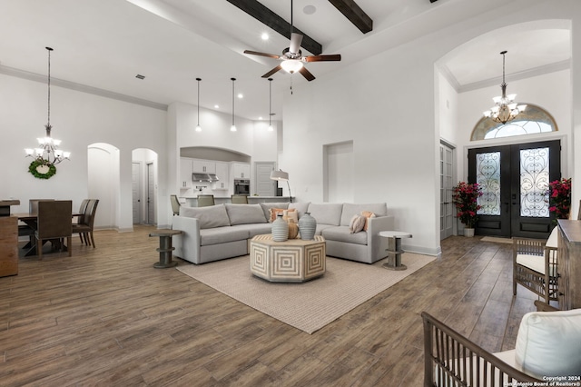 living room featuring ceiling fan with notable chandelier, a high ceiling, wood-type flooring, french doors, and crown molding