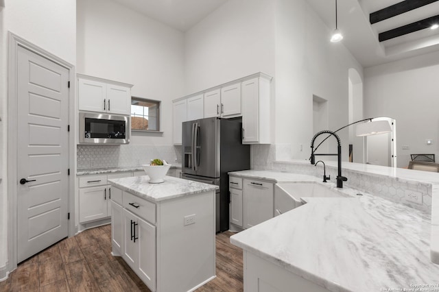 kitchen with dark hardwood / wood-style flooring, decorative backsplash, a towering ceiling, and stainless steel appliances