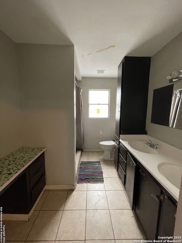 bathroom with tile patterned floors, toilet, walk in shower, and vanity