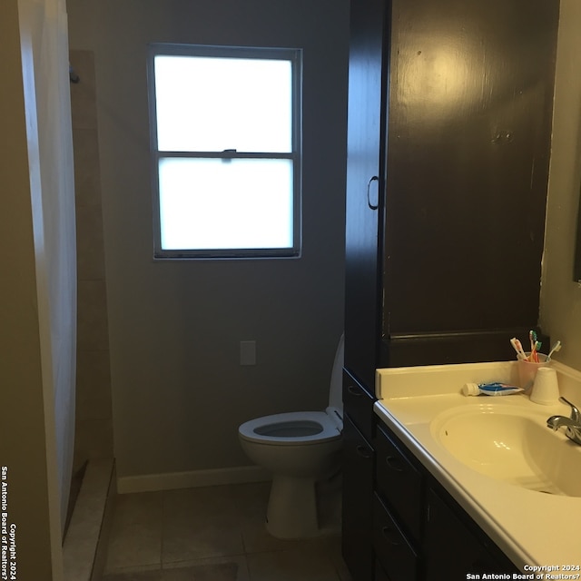 bathroom featuring toilet, vanity, curtained shower, and tile patterned floors