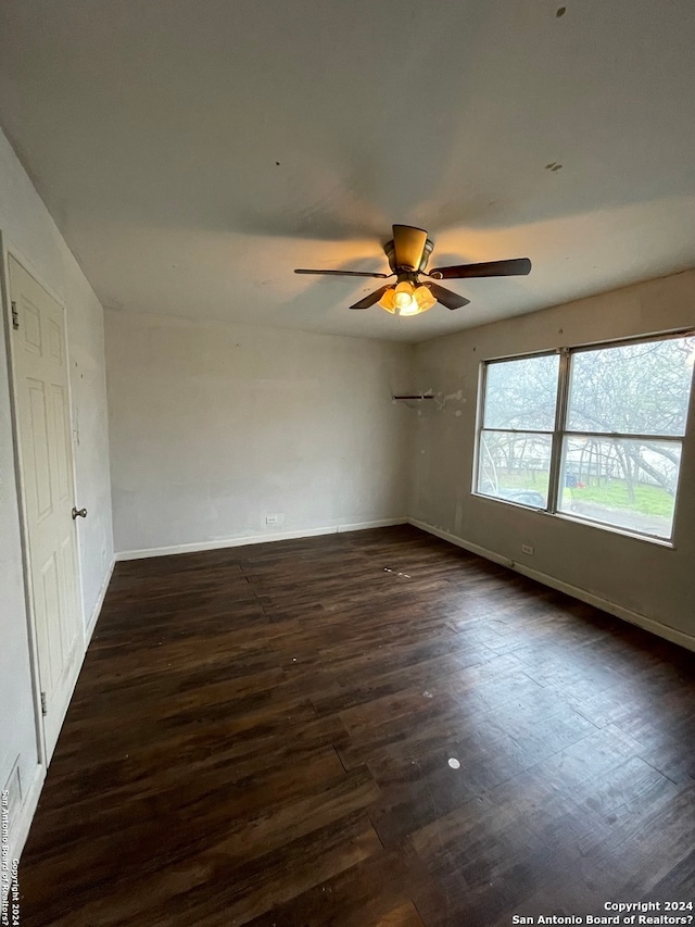 empty room with dark hardwood / wood-style flooring and ceiling fan