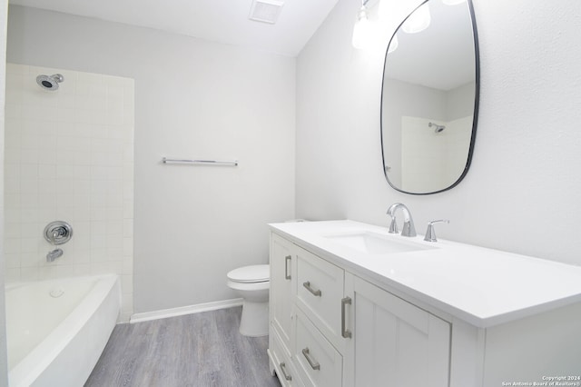 full bathroom with toilet, vanity, tiled shower / bath combo, and wood-type flooring