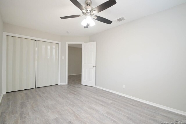 unfurnished bedroom featuring light wood-type flooring, a closet, and ceiling fan