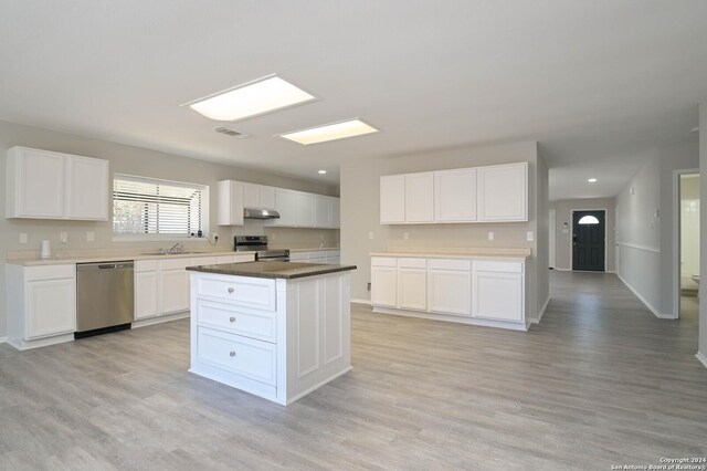 kitchen with white cabinetry, light hardwood / wood-style floors, stainless steel appliances, and a kitchen island