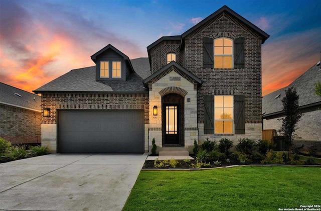 french provincial home with a yard and a garage