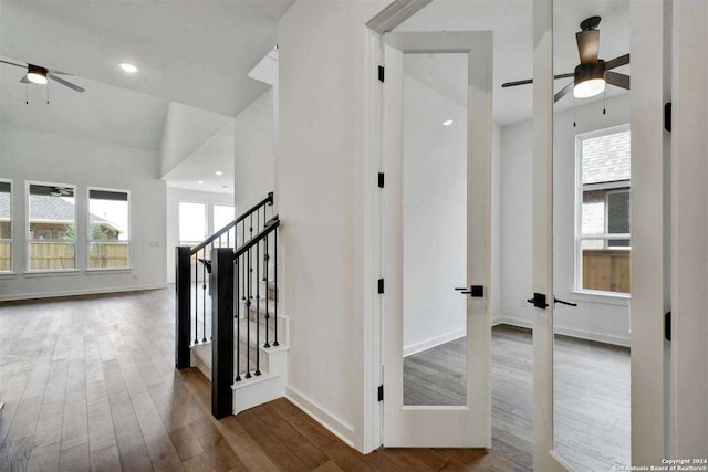 stairs with ceiling fan, vaulted ceiling, hardwood / wood-style floors, and a healthy amount of sunlight